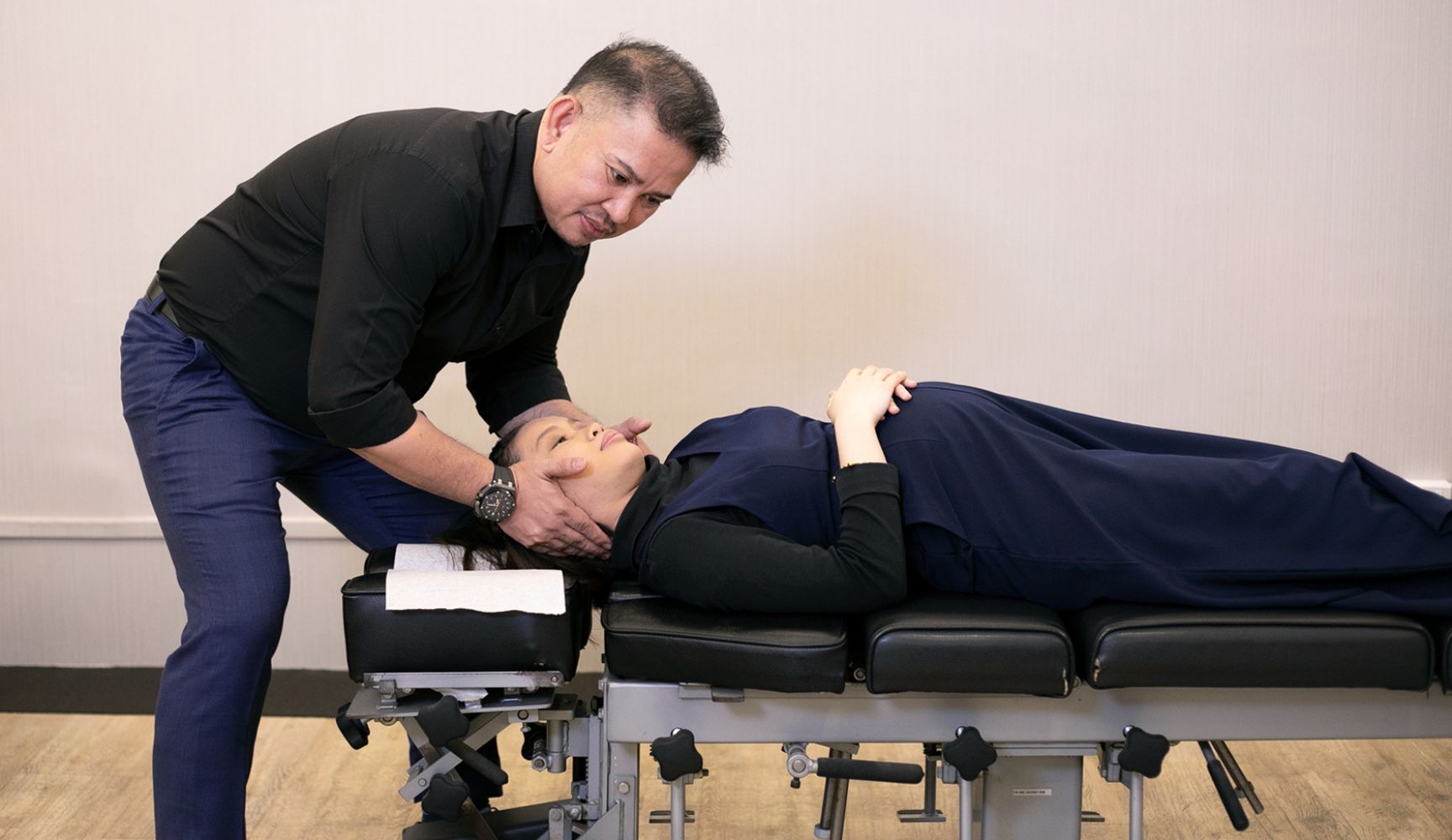 Chiropractor adjusting a pregnant woman’s neck on a treatment table