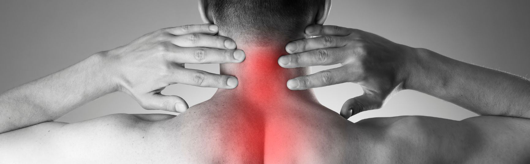 Man holding the back of his neck, with the pinched nerve area highlighted