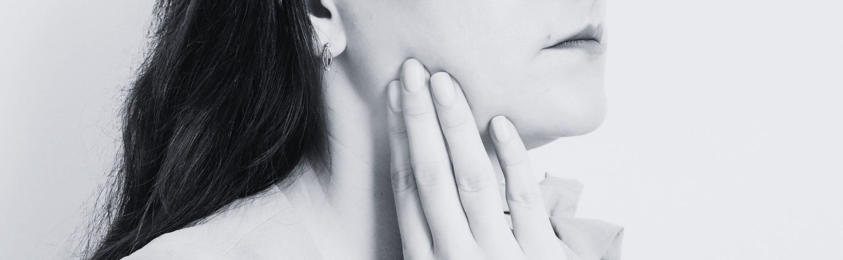 Woman holding her jaw in pain from a TMJ disorder