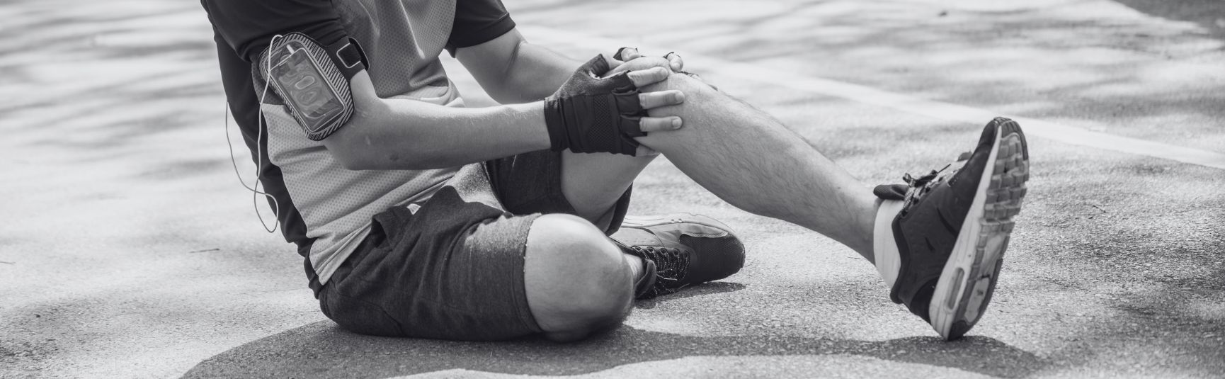 Man holding his leg after straining a muscle while jogging