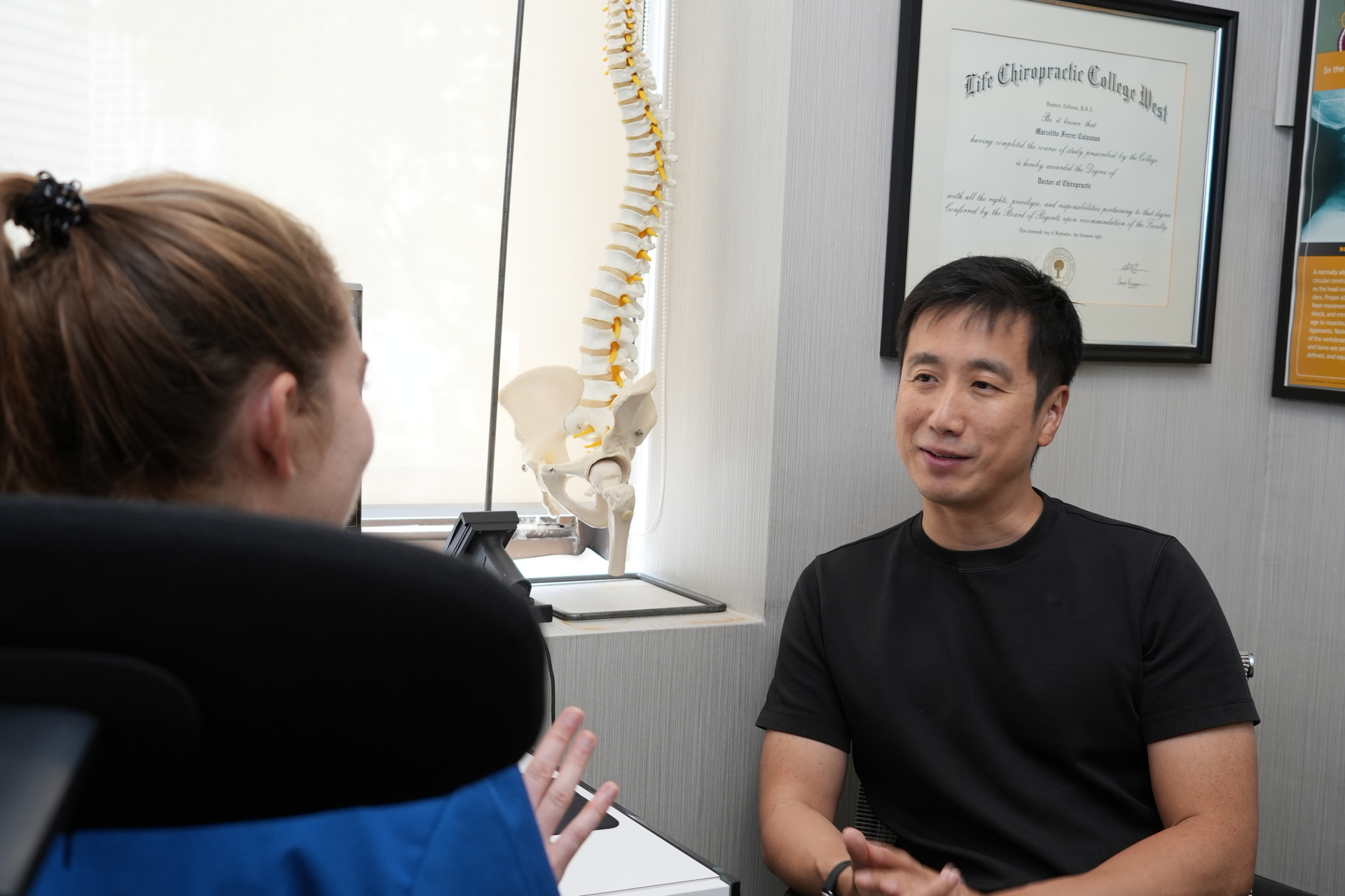 Healing Hands chiropractor explaining spine model during a consultation