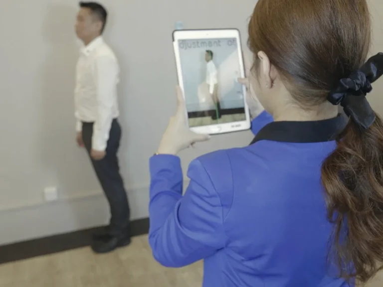 Healing Hands team member taking a posture analysis scan on a tablet